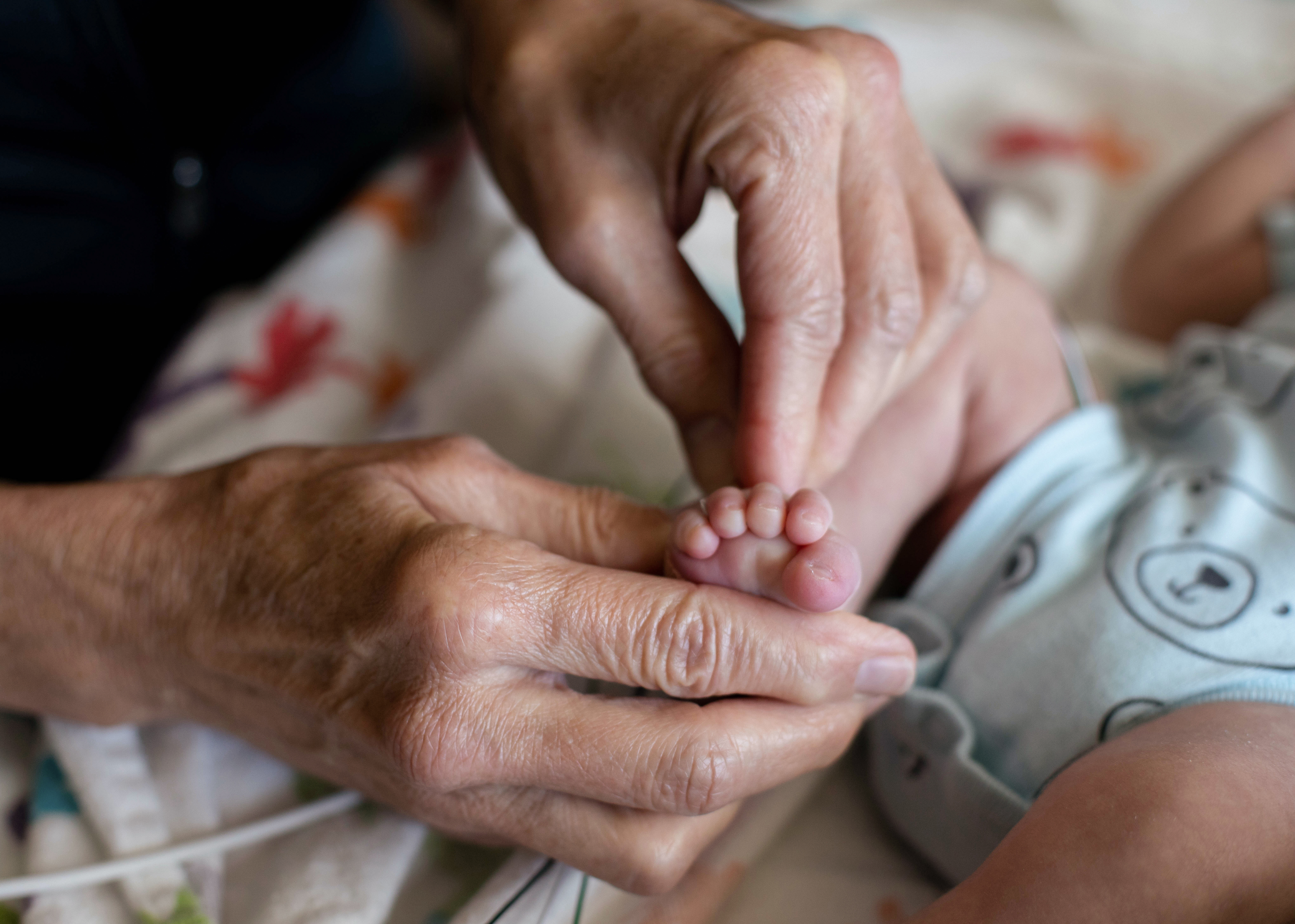 Adult hand holding baby’s foot